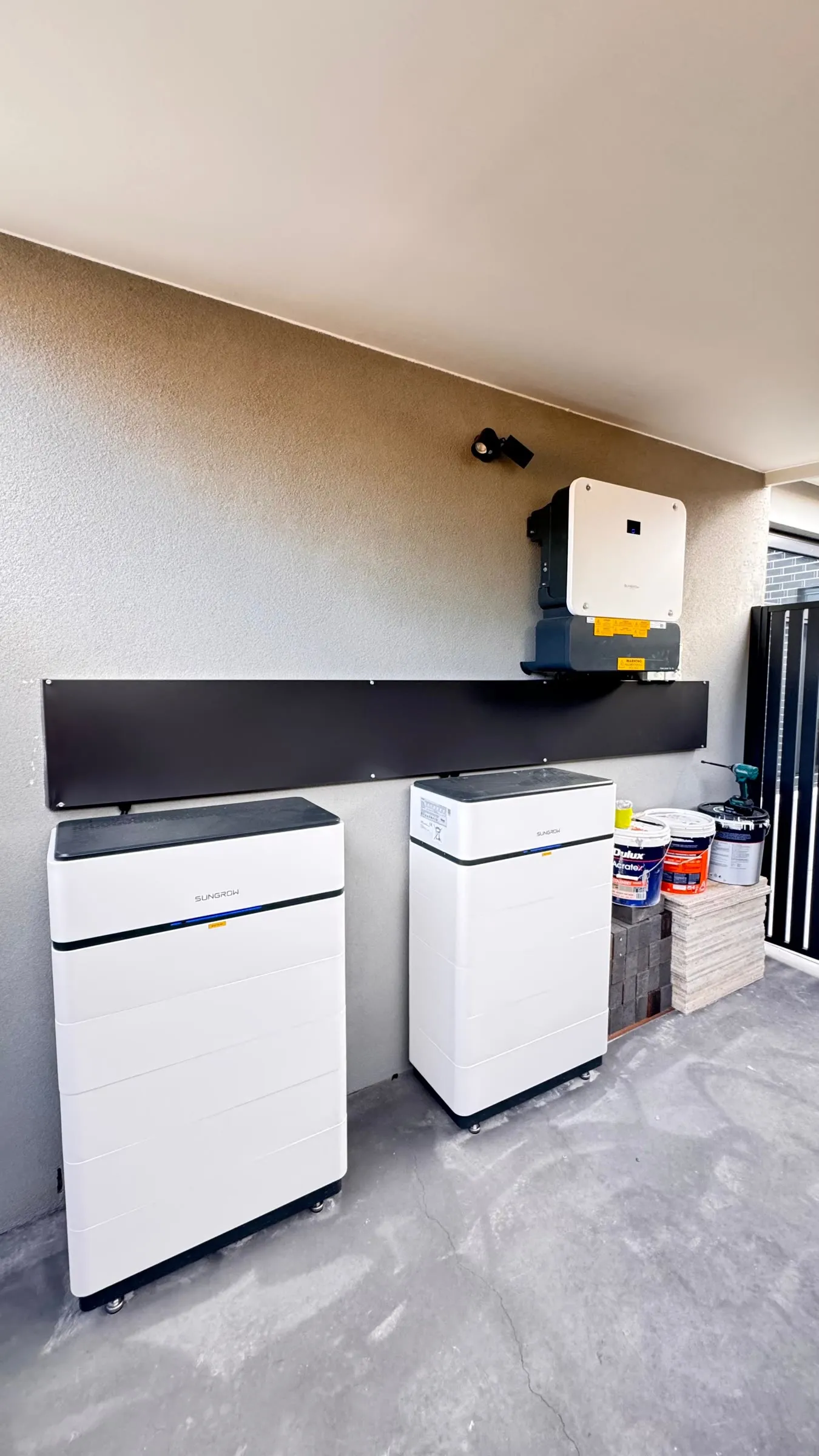 Two Sungrow SBH battery stacks and the inverter installed against a wall at the clinic