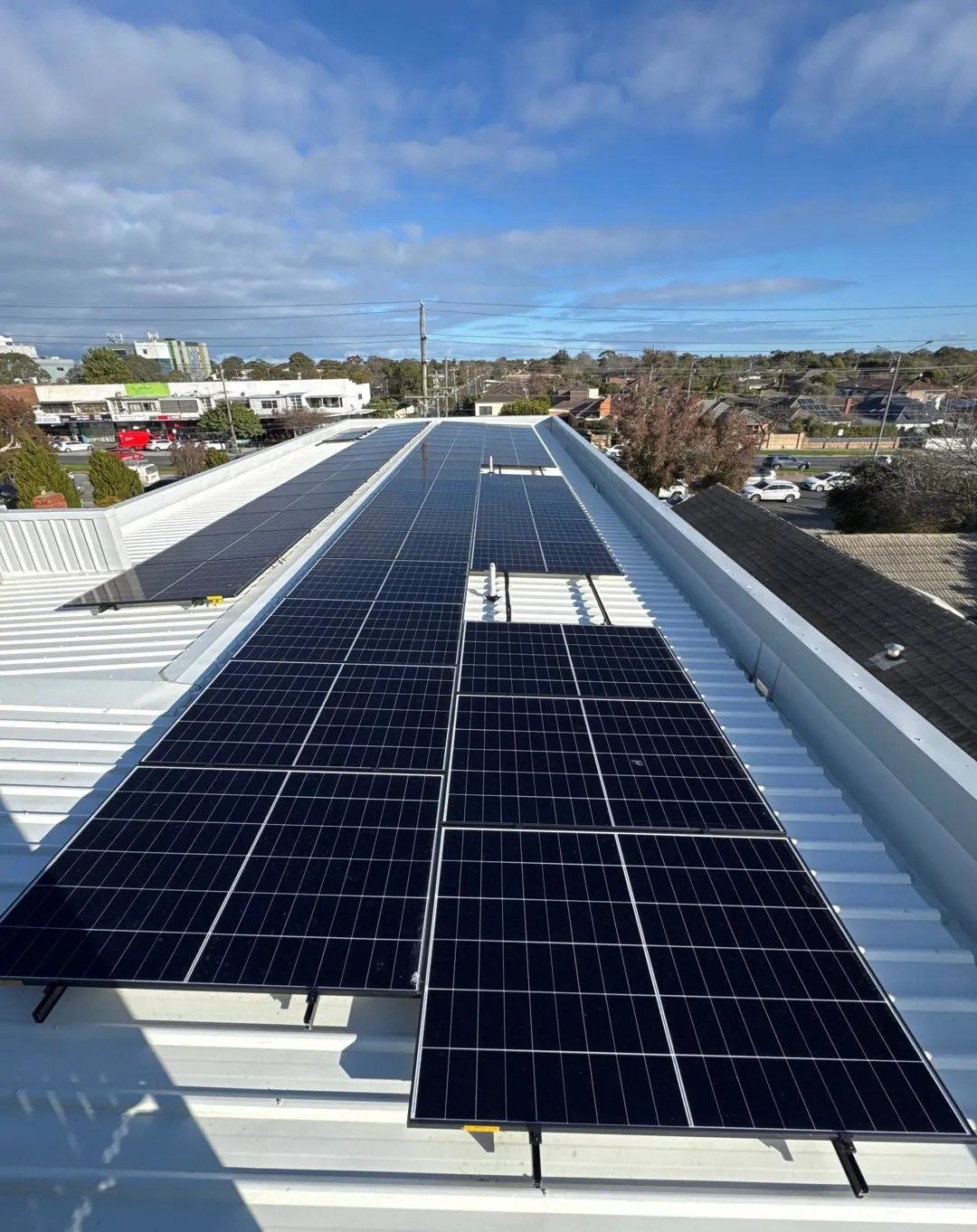 Rows of LONGi solar panels across the clinic's metal roof